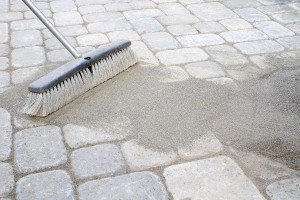 Broom Sweeping Sand Into Pavers