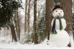 Large snowman standing in the park while it's snowing