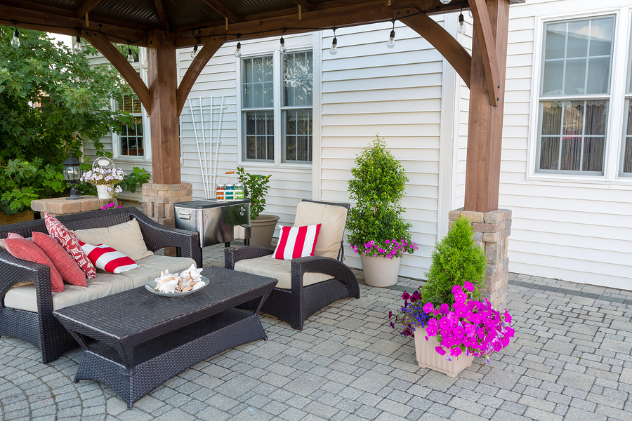 Beautiful outdoor living space with pergola and potted flowers.
