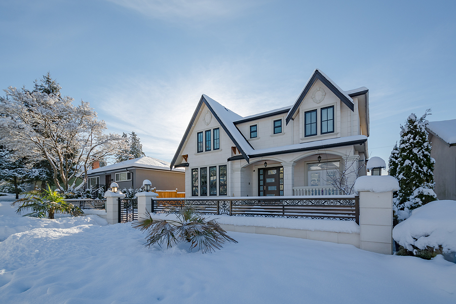 Luxurious residential house with front yard in snow. North American family house on winter sunny day