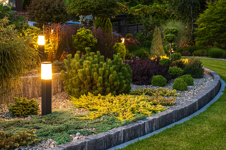 Terraced flowerbeds with greenery, shrubs, and decorative stone with lanterns.