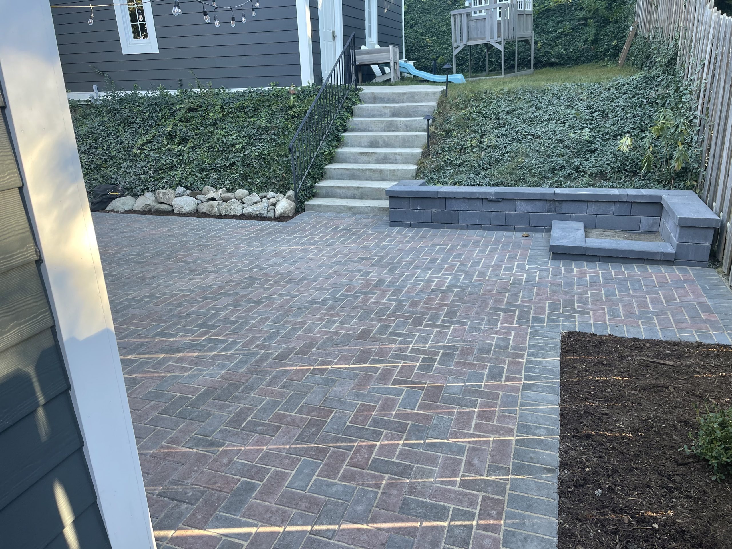 Finished patio and retaining wall with drainage solution.