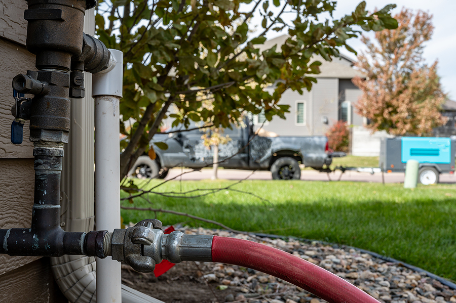Professional landscaper winterizing a residential irrigation system. 