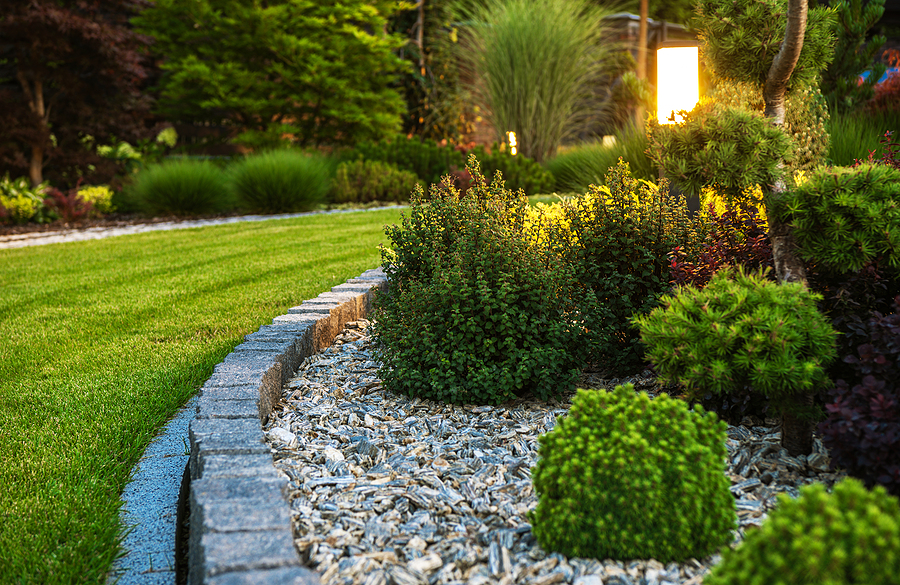 Closeup of a professionally landscaped flower bed with lighting. 